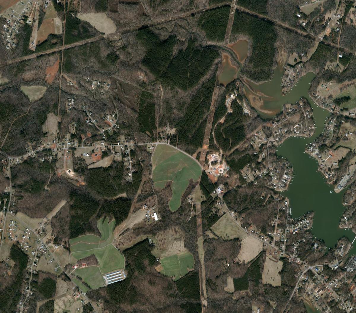 Official aerial view of forest, fields, roads, and Lake Norman near Mountain Creek.
